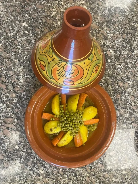 Couscous aux légumes servi dans un tajine décoré
