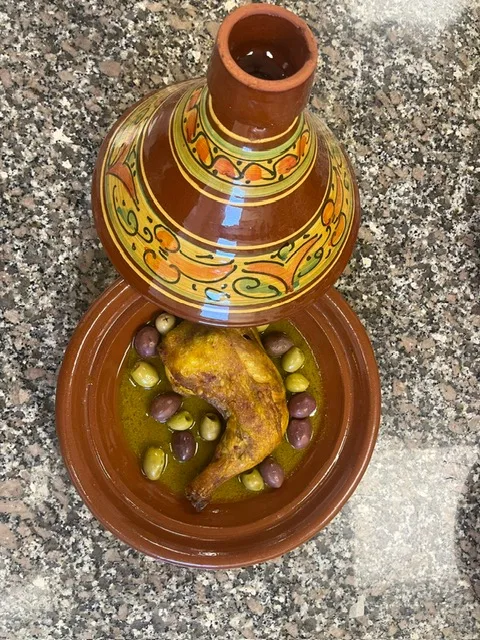 Tajine de poulet aux olives présenté en poterie traditionnelle